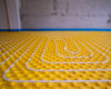 yellow underfloor heating installation with white pipes